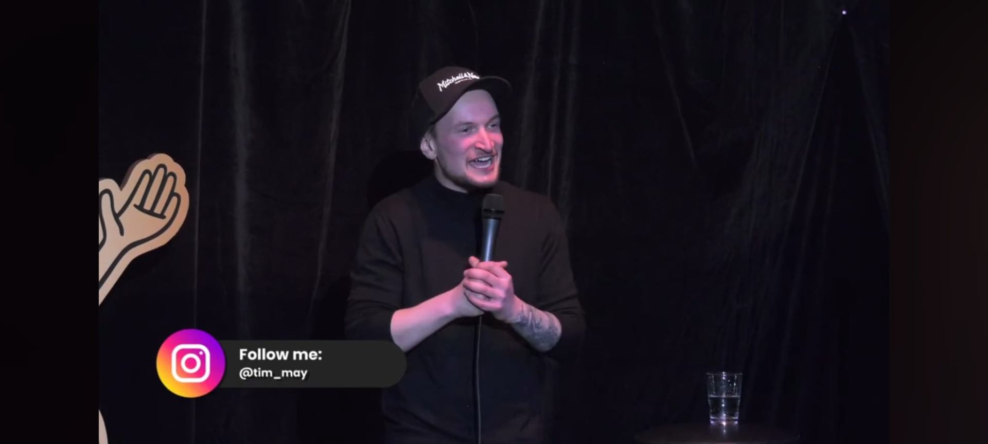 Comedian im Spotlight auf einer dunklen Club-Bühne